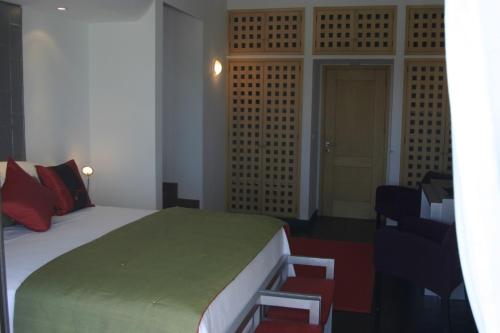 a bedroom with a bed and a chair and a door at Posada de los Pajaros in Punta del Este