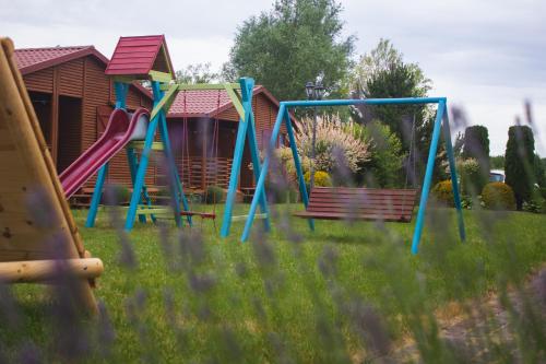 un parque infantil con un tobogán y un banco en un patio en Domki u Bukowskich en Jezierzany