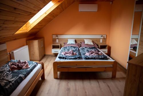 a bedroom with two beds in a attic at Benige vendégház in Demjén