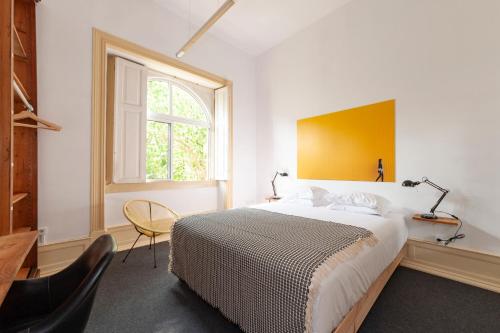 a bedroom with a large bed and a window at Cheese & Wine Lapa in Lisbon