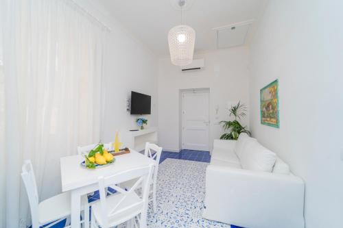 een witte woonkamer met een witte tafel en stoelen bij Relais Capitolo in Maiori
