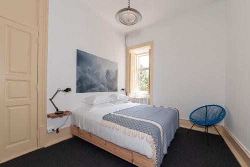 a bedroom with a bed and a lamp and a window at Cheese & Wine Lapa in Lisbon