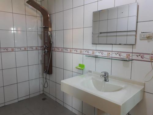 Un baño blanco con lavabo y espejo. en Beido Qixing, en Beidou