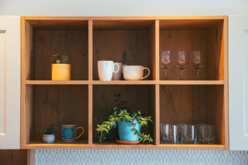 a wooden cabinet with cups and plants in it at Beachfront Comfort Apartment NIVES in Tučepi
