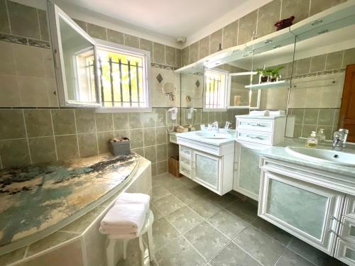ein Badezimmer mit 2 Waschbecken und einer Badewanne in der Unterkunft Chambres d'hôtes Les Noisetiers in Digne-les-Bains