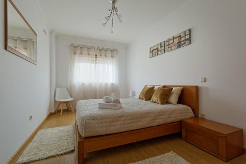 ナザレにあるAlojamento Santo António IIのベッドと窓のある寝室