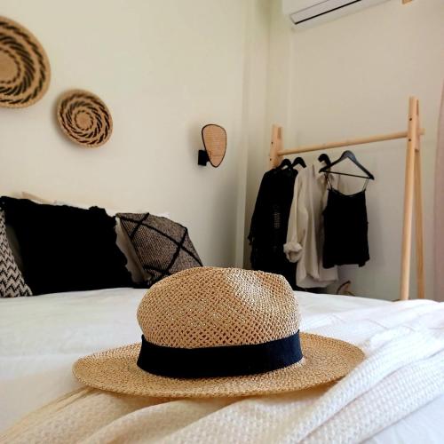 a straw hat sitting on top of a bed at nisaki rooms & apartments in Methana