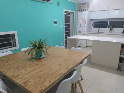 uma cozinha com uma mesa de madeira e electrodomésticos brancos em Casa con pileta en Rosario em Rosário