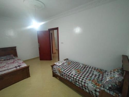 Sala de estar con 2 camas y puerta en Oued laou واد لو, en Oued Laou