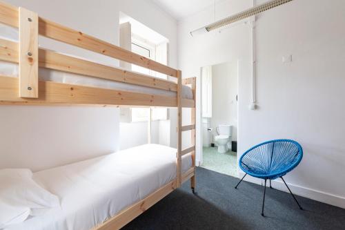 a bedroom with a bunk bed and a blue chair at Cheese & Wine Lapa in Lisbon