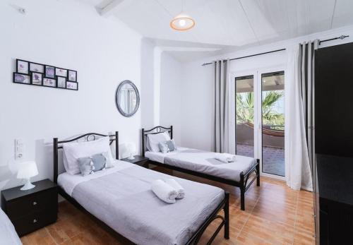 a bedroom with two beds and a window at Katerina’s Lux Home in Gerokampos Beach