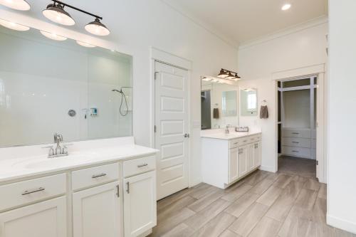 Baño blanco con 2 lavabos y espejo grande en Goodyear Vacation Rental with Private Hot Tub, en Goodyear