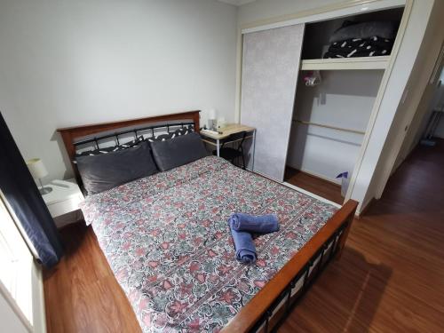 a bedroom with a large bed with a blue object on it at Shared house with other guests near shopping center and theme parks in Gold Coast