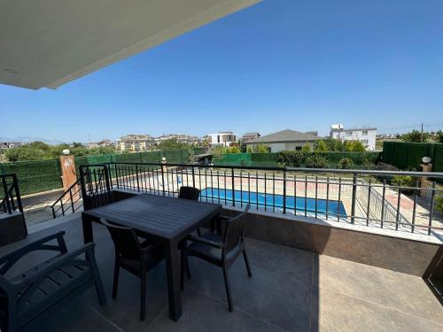 a balcony with a table and chairs and a swimming pool at Villa mila in Belek