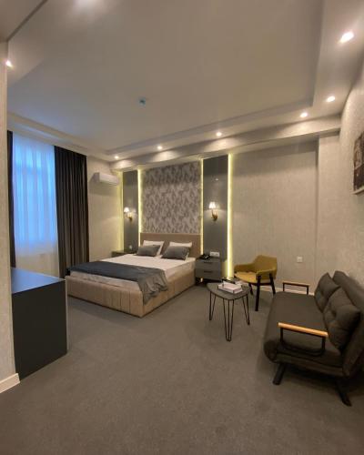 una camera con letto, divano e sedia di EZ Restoran & Hotel a Zaqatala