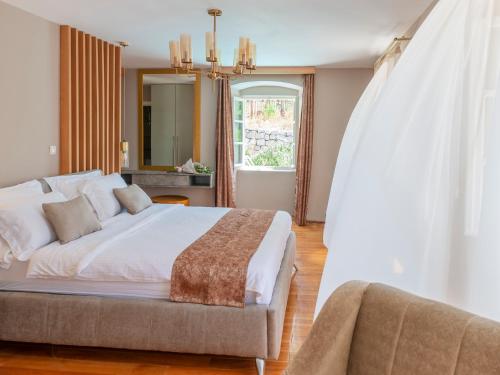 a bedroom with a large white bed and a couch at Villa Feliz in Kotor
