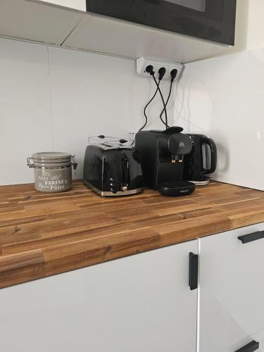 a kitchen counter top with a microwave and appliances on it at L'Idrac, Appartements en Hyper centre in Toulouse