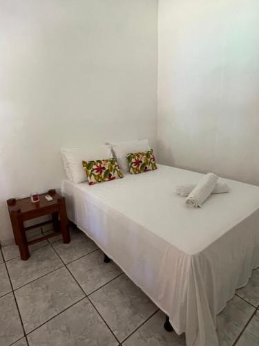 a bed in a room with a side table at Casa Trancoso in Trancoso