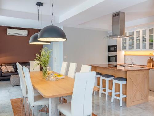a kitchen and dining room with a wooden table and white chairs at Villa Feliz in Kotor
