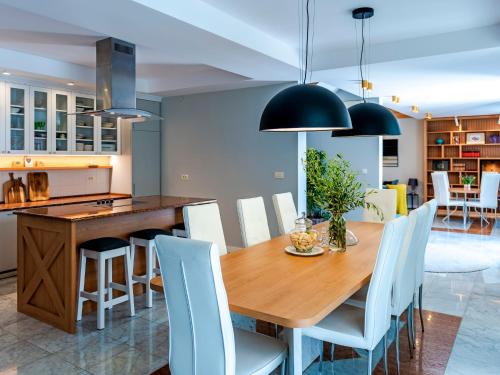 a kitchen and dining room with a wooden table and white chairs at Villa Feliz in Kotor