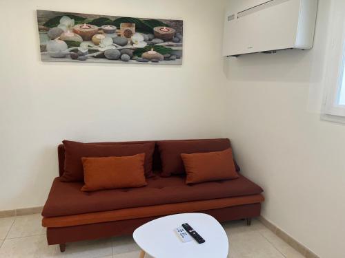 un salon avec un canapé marron et une table dans l'établissement Appartement au bor de mer, à Marseille