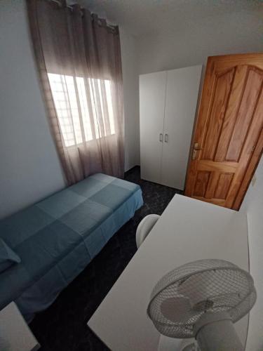 a small bedroom with a blue bed and a door at APARTAMENTO C. LA VILLA TEO in La Laguna