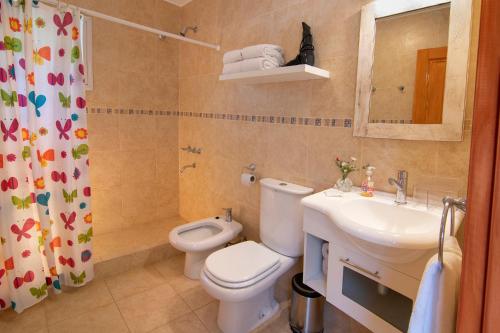 a bathroom with a toilet and a sink and a mirror at Cabaña para relajarse con vista panorámica in Villa General Belgrano
