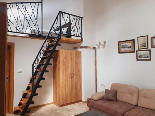 a living room with a spiral staircase and a couch at Fruškogorski biser in Sremski Karlovci
