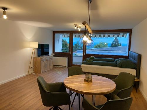 sala de estar con sofá y mesa en Apartment Bergpanorama mit wunderschönem Alpenpanorama und Indoor-Pool, en Oberteuringen