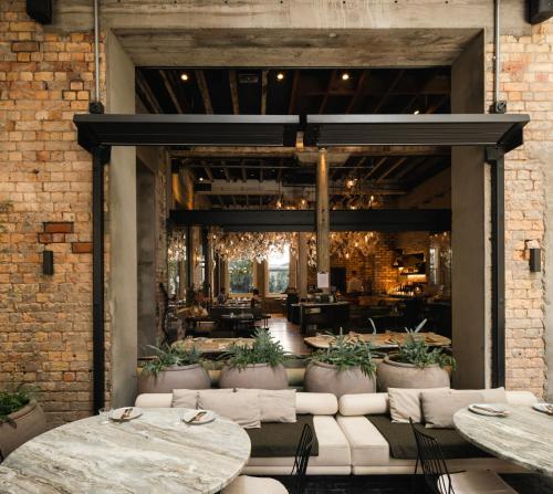 a restaurant with tables and chairs and a brick wall at The Hotel Britomart in Auckland