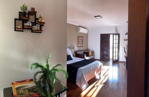 a bedroom with a bed and a plant in a room at Hospedaria Canto do Vinhedo in Espirito Santo Do Pinhal