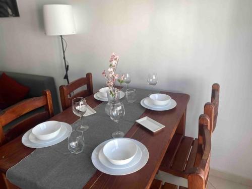 een eettafel met borden en wijnglazen bij joy house +équipement de plage(chaises et parasol) in Martil