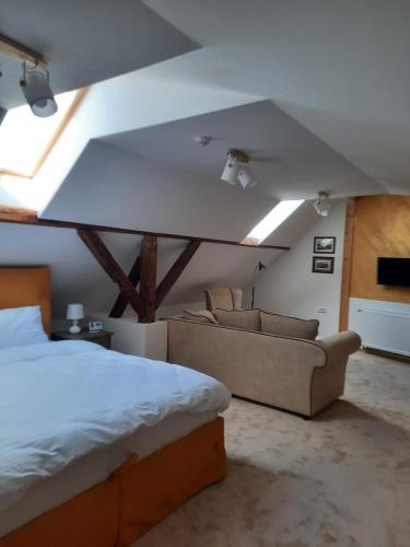 a bedroom with a bed and couches in a room at Fruškogorski biser in Sremski Karlovci