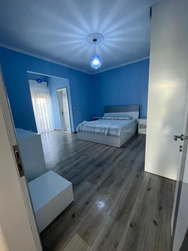 a blue room with two beds and a couch at Vila Gregor in Tushemisht