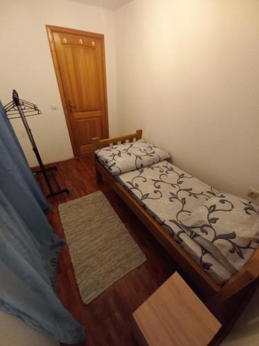 a bedroom with a bed and a wooden floor at Vikendica Savić in Šipovo