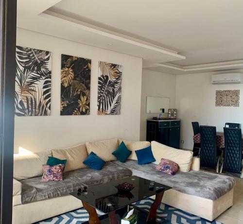 sala de estar con sofá y mesa en Prestigia plage des nations , OCEAN VIEW en Sidi Bouqnadel
