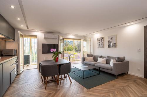 un salon avec un canapé et une table dans l'établissement Heart of Cannes contemporary 2BR garden view Palais & Croisette 5 mn by Olam Properties, à Cannes