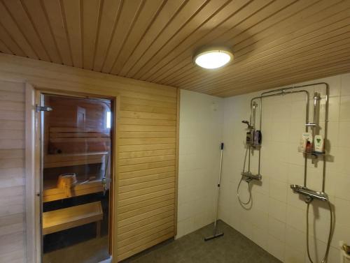 een badkamer met een douche en een glazen deur bij Omakotitalo rauhallisella alueella in Rauma