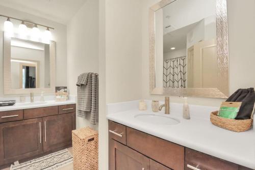 a bathroom with two sinks and a large mirror at Lux Mid-Rise Walking Distance to NRG Stadium in Houston