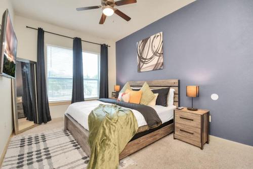 a bedroom with a large bed and a ceiling fan at Lux Mid-Rise Walking Distance to NRG Stadium in Houston