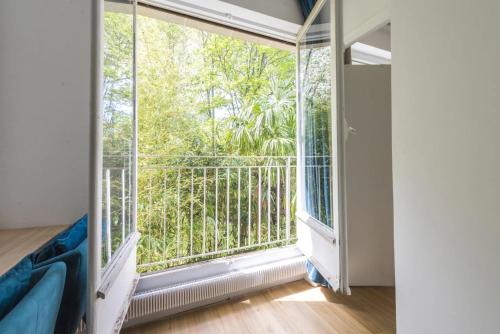 Habitación con ventana grande y balcón. en Appartement 2 pièces 4 couchages tout confort, en Neuilly-sur-Seine