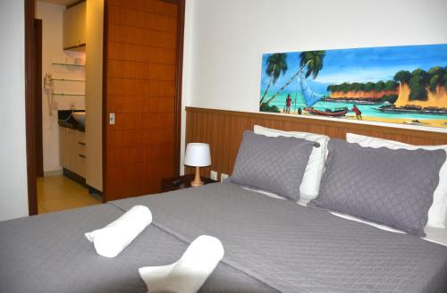a bedroom with a bed and a painting on the wall at Apartamento a Beira Mar no Flat Elegance in Natal