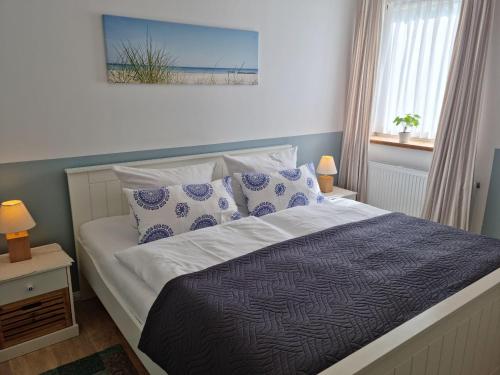 een slaapkamer met een bed met blauwe en witte kussens bij Ferienwohnung-Wiesenblick-mit-GRATIS-Leistungen in Thesenvitz