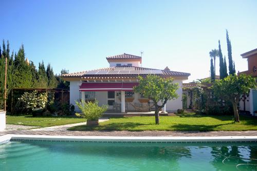una casa con piscina frente a ella en Chalets en Sancti Petri, en Novo Sancti Petri