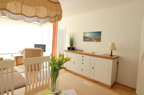ein Wohnzimmer mit einem Tisch und einem Schreibtisch in der Unterkunft Frische Brise 12.03 in Cuxhaven