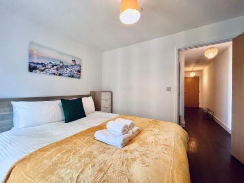 a bedroom with a large bed with towels on it at Venice Court London 2Bedroom Apartment in London