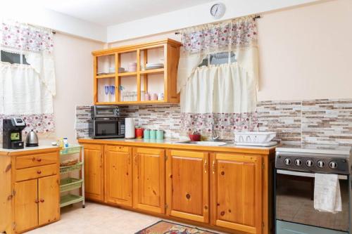 uma cozinha com armários de madeira e um fogão em Dette's Nook em Roseau