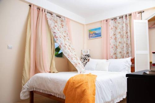 um quarto com uma cama de dossel e uma janela em Dette's Nook em Roseau