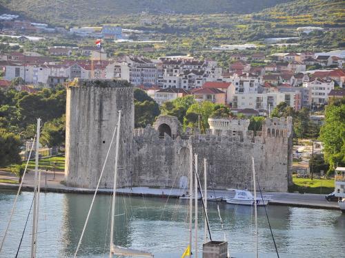a castle on a river with boats in the water at Villa Bakica in Trogir