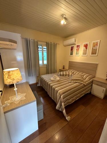 a bedroom with a large bed and a desk at Apartamento 2 Quartos até 5 pessoas - Gramado in Gramado